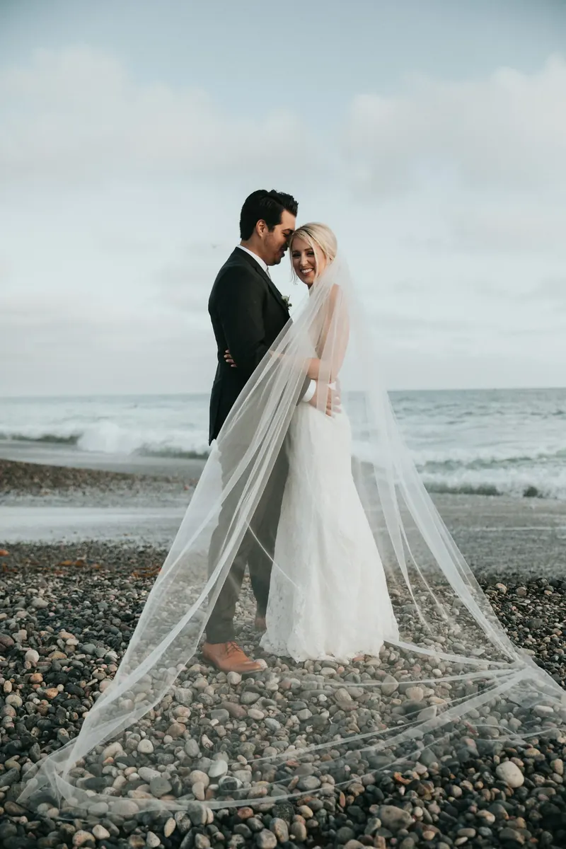 A bride and groom sharing a quiet moment beside the sea